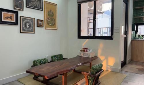 a dining room with a wooden table and chairs at Niu Homestay in An Khê
