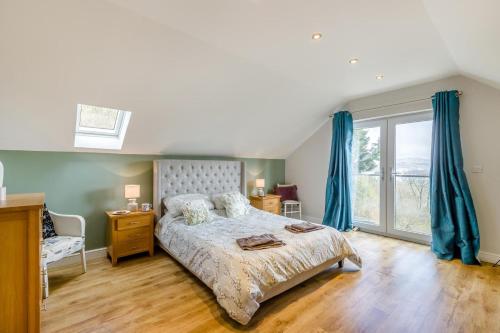 a bedroom with a bed and a window with blue curtains at 4 Bed in Goodwick oc-s34887 in Goodwick