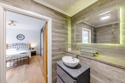 a bathroom with a sink and a bed in a room at 4 Bed in Goodwick oc-s34887 in Goodwick