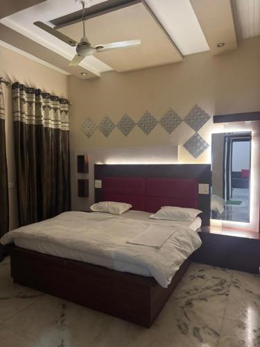 a bedroom with a large bed and a window at Auranest Stays Duplex Home in Ludhiana