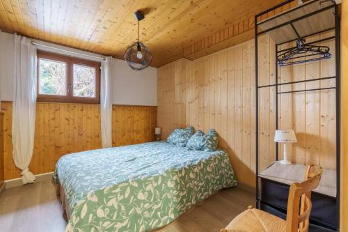 a bedroom with a bed in a room with wooden walls at Clairmatin - Plein Centre de La Bresse in La Bresse