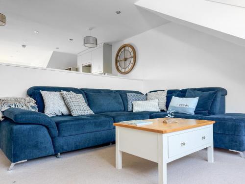 a blue couch in a living room with a table at Headlands Hideaway in Coverack