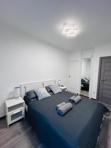 a bedroom with a large bed with blue sheets and pillows at Alex Vip Apartman in Hajdúszoboszló