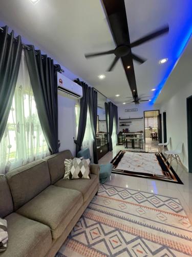 a living room with a couch and a ceiling fan at Afiq's Homestay, Manjung in Seri Manjung