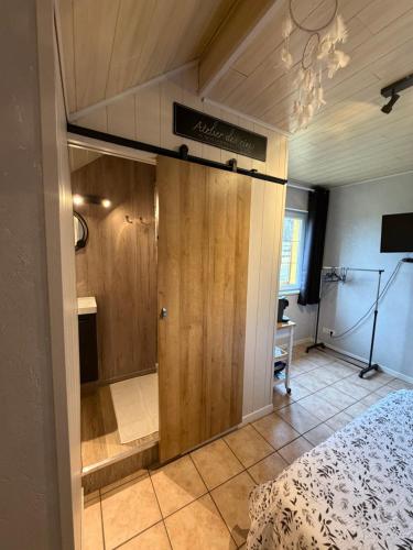 a bedroom with a bed and a door in a room at HOME SÉRÉNITÉ in Hazelbourg