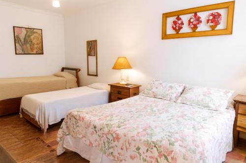 a bedroom with two beds and a lamp on a table at Tiradentes Pousada Ramalhete in Tiradentes