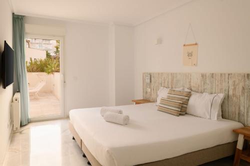 a bedroom with a large white bed and a patio at Dormio Resort Costa Blanca Beach & Spa in El Campello