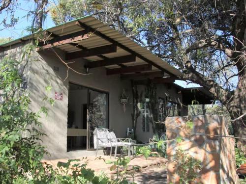 ein Haus mit einem Tisch und einem Stuhl davor in der Unterkunft Hidden Spaces in Mooinooi