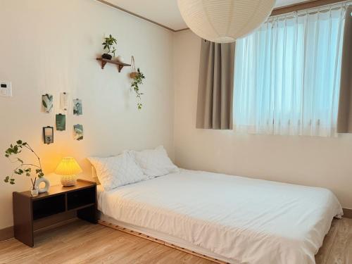 a bedroom with a white bed and a window at Ansik in Busan
