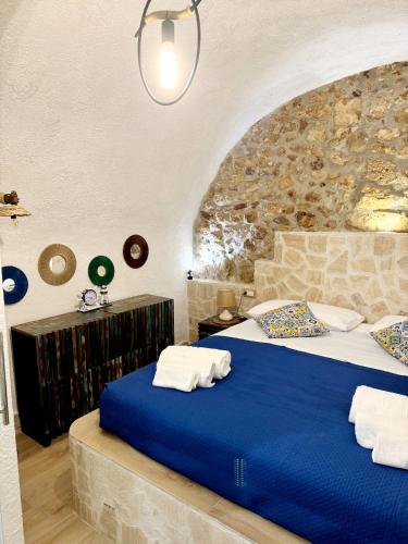 a bedroom with a blue bed with a stone wall at Mare' in Vieste
