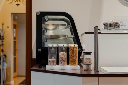 a kitchen counter with a food machine with containers of food at Hotel & Gasthaus Backmulde in Heidelberg