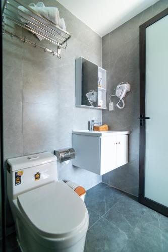 a bathroom with a white toilet and a sink at Villa Layna's home in An Bàn (2)