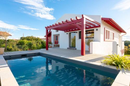 a villa with a swimming pool and a house at SUNSET Keyweek Villa ocean view and private pool in Bidart