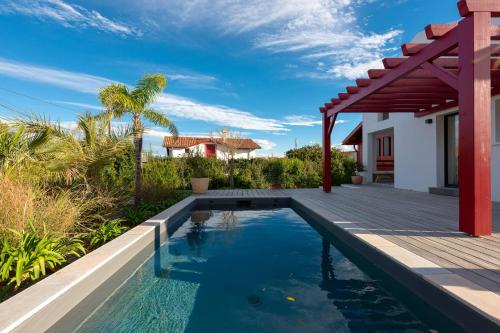 a swimming pool with a deck and a house at SUNSET Keyweek Villa ocean view and private pool in Bidart