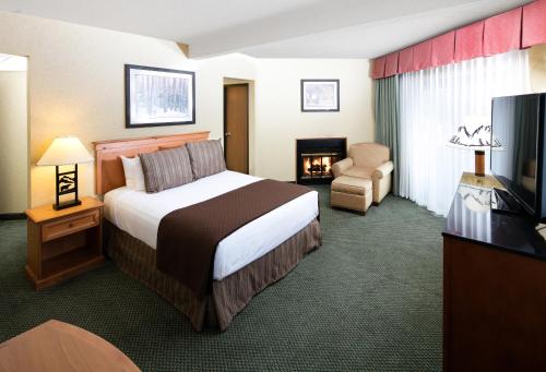 um quarto de hotel com uma cama e uma cadeira em Red Lion Hotel Kalispell em Kalispell