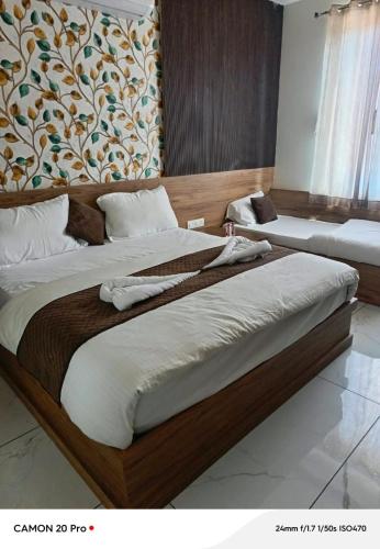 two large beds in a bedroom with a wall at Hotel Pushkar Town in Pushkar