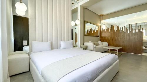 a bedroom with a large white bed and a living room at Beautiful Asma Villa with pool in Marrakesh
