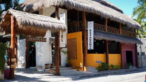 a building with a straw roof on a beach at Hotel Diosa del Agua Bacalar in Bacalar