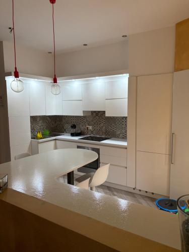 a kitchen with white cabinets and a table with chairs at La Concordia in Novi Ligure