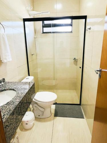 a bathroom with a shower and a toilet and a sink at Ap3 - Studio Confortável e Tranquilo in Guaíra