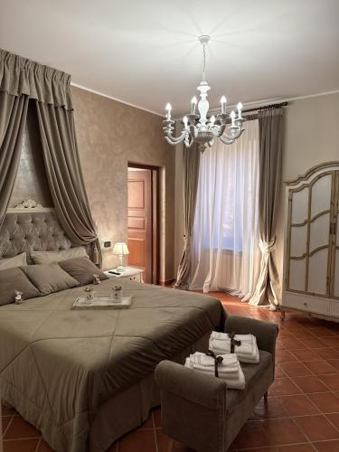 a bedroom with a large bed and a chandelier at La Dimora in Morino