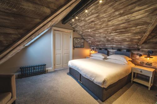 a bedroom with a large bed and a wooden ceiling at The Fleece Hotel Richmond in Richmond