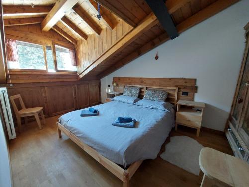 a bedroom with a large bed and a wooden ceiling at Petit Chalet in Villanova