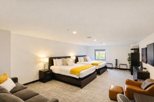 a hotel room with two beds and a couch at The 419 Ten-Room Boutique in Sandusky in Sandusky