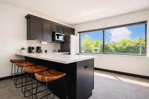 a kitchen with black cabinets and a counter with stools at The 419 Ten-Room Boutique in Sandusky in Sandusky
