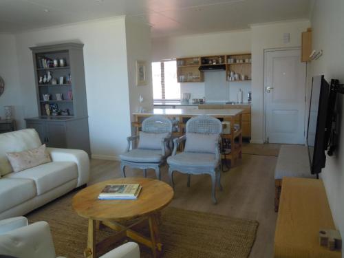 a living room with a couch and chairs and a table at King Fisher 6 in Mossel Bay