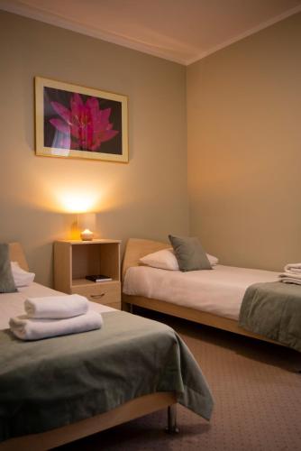 a room with two beds and a picture on the wall at Villa FOREST in Poznań
