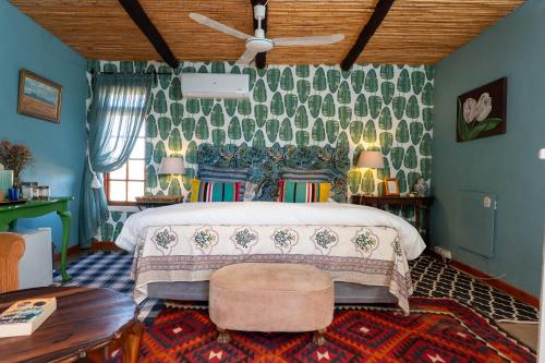 a bedroom with a bed and a couch and a table at Kuilfontein Stable Cottages in Colesberg