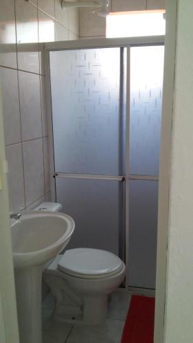 a bathroom with a toilet and a sink at Suite Recanto Cheiro Verde in Caraguatatuba