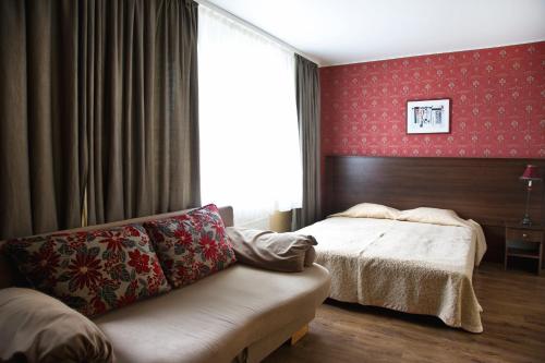 a hotel room with a bed and a couch at Mamos virtuve in Avižieniai