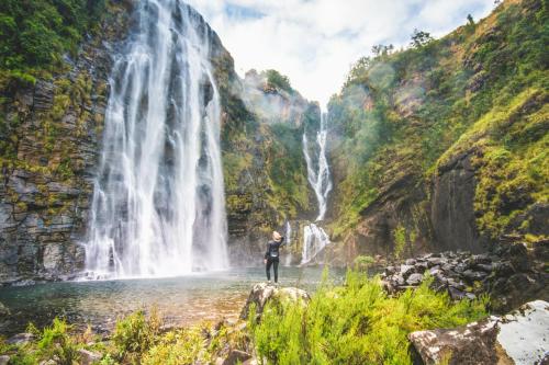 a man standing in front of a waterfall at Round Here Self-Catering Holiday Home in Sabie