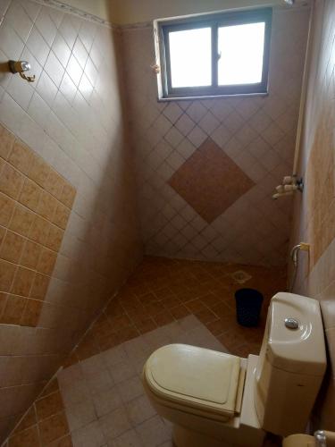 a bathroom with a toilet and a window at Proxima Quarters in Rawalpindi