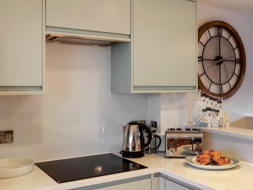 a kitchen with a plate of food and a clock at Headlands Hideaway in Coverack