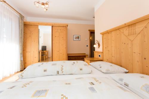 a bedroom with a large bed with a wooden headboard at Gasthaus zum Weissen Kreuz in Lazfons