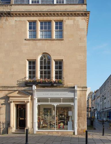 a store front of a brick building with flowers in the window at 8 Holland Street Townhouse Bath in Bath