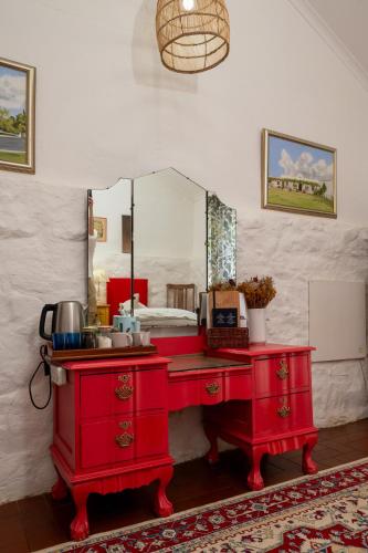 a red vanity with a mirror and a red dresser at Kuilfontein Stable Cottages in Colesberg