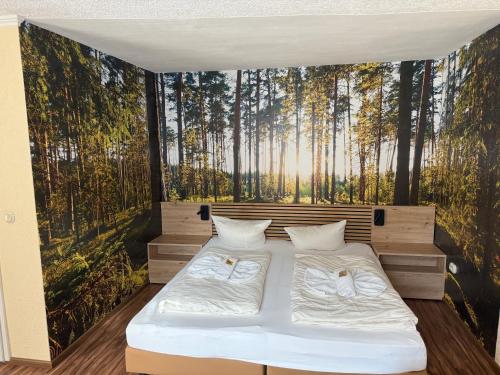 a bedroom with two beds in a forest mural at Natur& Waldhotel Johannesruh in Wesenberg