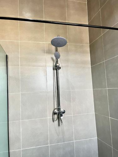 a shower with a shower head on a tiled wall at Lux-Home Enugu in Enugu