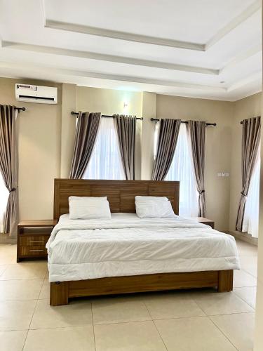 a bedroom with a large bed with white sheets at Lux-Home Enugu in Enugu