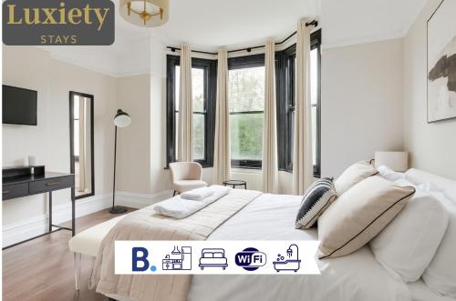 a white bedroom with a bed and a desk at City Centre GuestHouse By Luxiety Stays Cambridge Perfect For Families With Affordable Rates in Cambridge