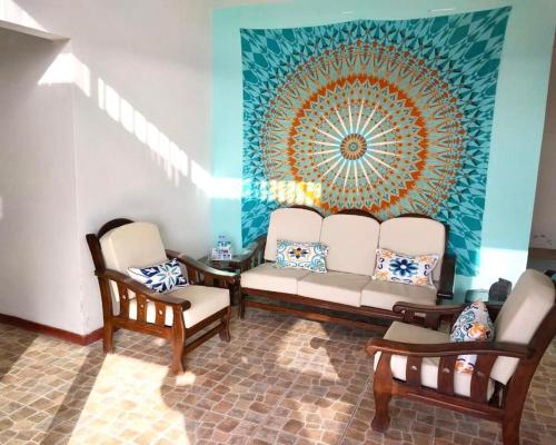 a living room with two chairs and a couch at Casuarinas Del Mar Chalet de 2 habitaciones in Canoas de Punta Sal