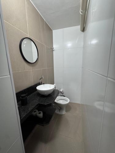 a bathroom with a sink and a toilet and a mirror at Book a bed Jacumã in Conde