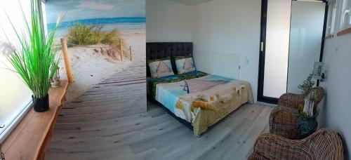 a bedroom with a bed and a view of the beach at Thuis op Flakkee in Ooltgensplaat
