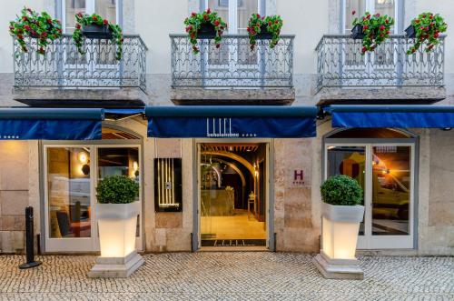 a facade of a building with blue umbrellas and plants at behotelisboa in Lisbon