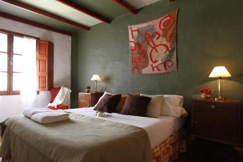 a bedroom with two beds and a painting on the wall at Hostería Lunahuana in Tafí del Valle