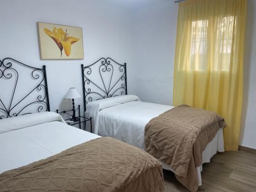 a hotel room with two beds and a window at El Olivar de la Solana in Castril
